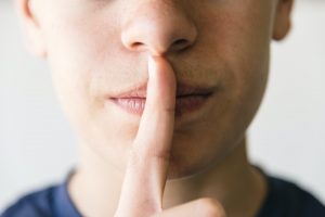 Young doing the gesture of silence with his finger