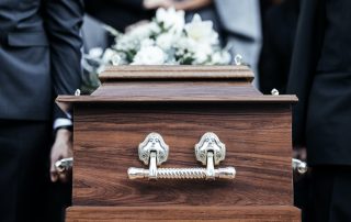 Coffin, people and funeral with death, grief and service with family carry casket to grave outdoor.